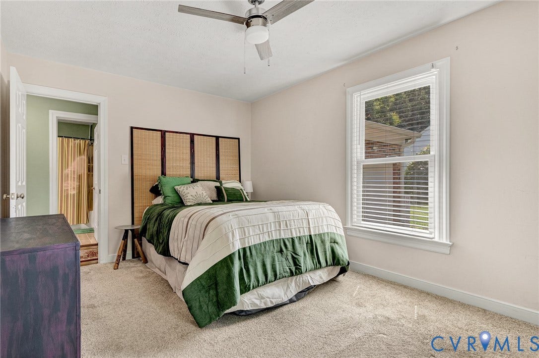 Neutral wall paint, ceiling fan with integrated lighting, window with blinds, carpet flooring