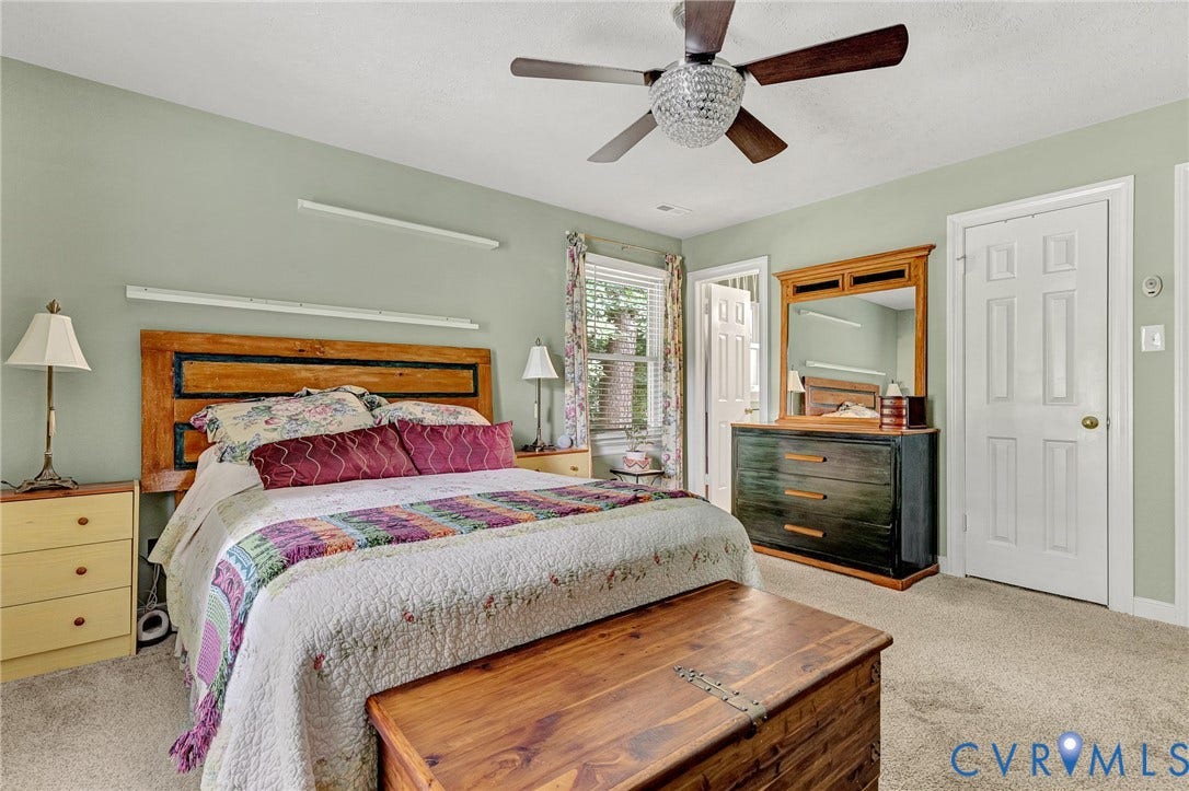 Wall-to-wall carpeting and a ceiling fan with integrated lighting