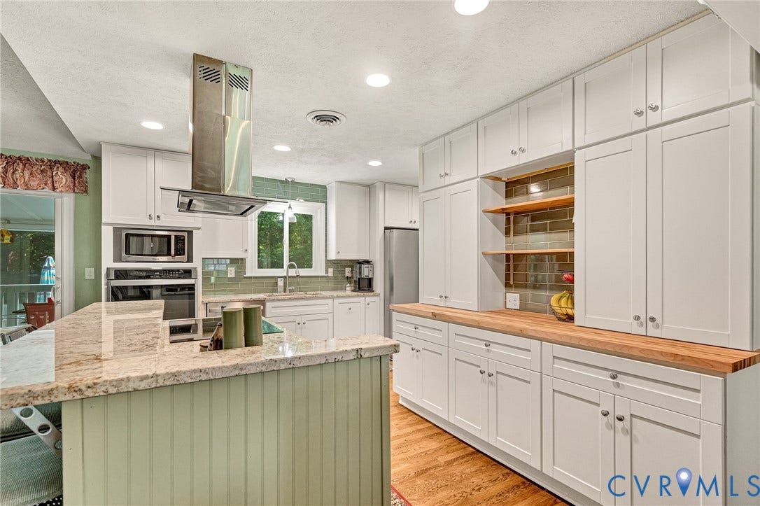 Kitchen featuring white cabinetry, built-in stainless steel appliances, a stainless steel range hood, stone countertops, and wood-finish flooring
