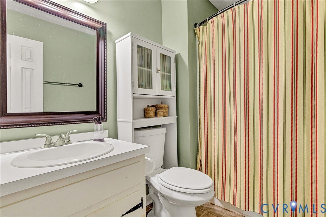 White vanity with integrated sink, dual-handle faucet, and white countertop