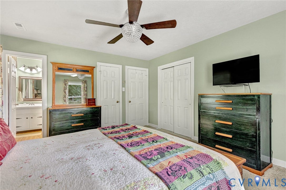 Spacious room featuring a ceiling fan with light fixture, two white bi-fold closet doors, and light-colored walls