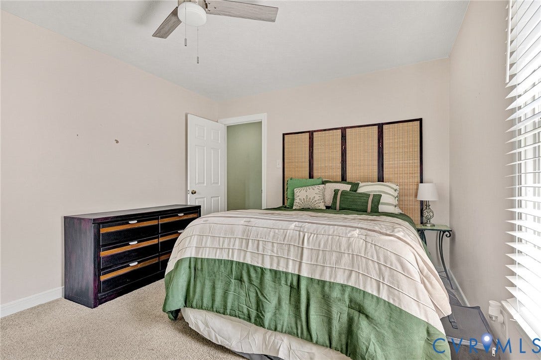 Wall-to-wall carpeting and a ceiling fan with light fixture