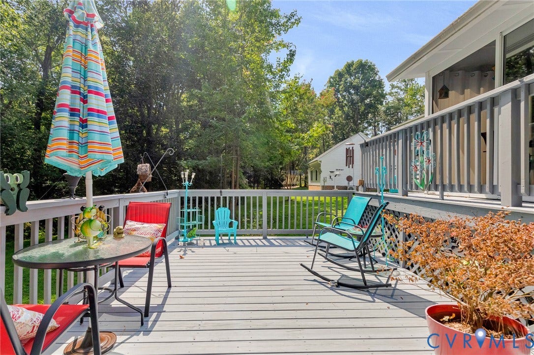 Expansive outdoor deck featuring wood-finish flooring, a white railing, and lattice detailing