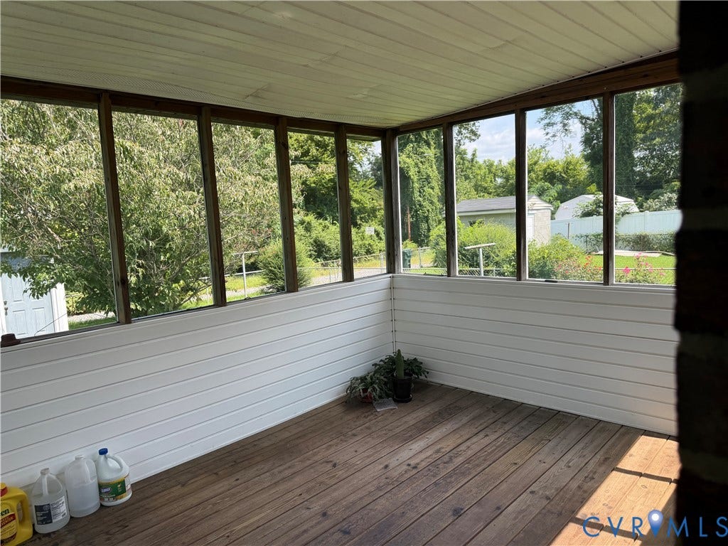 Screened porch with wood-finish flooring, white paneling, and a slatted ceiling