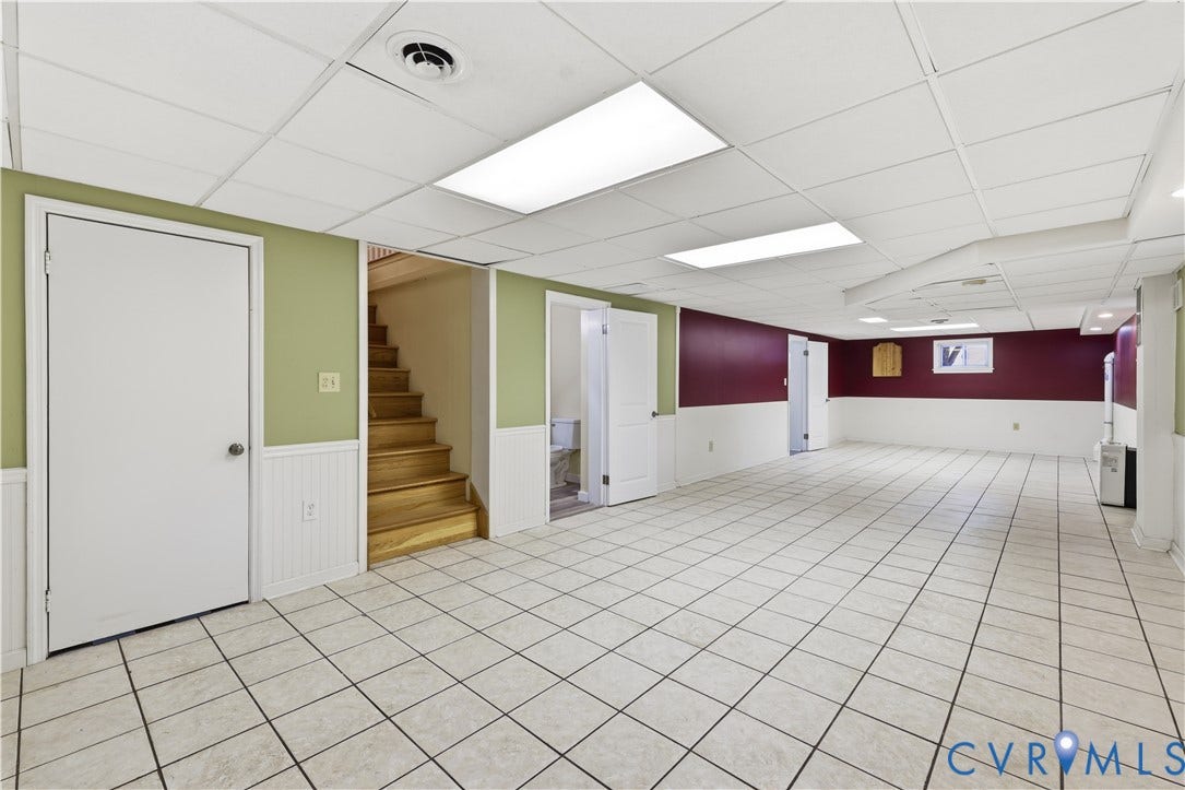 Spacious room featuring light-toned tile flooring, recessed lighting, and a drop ceiling
