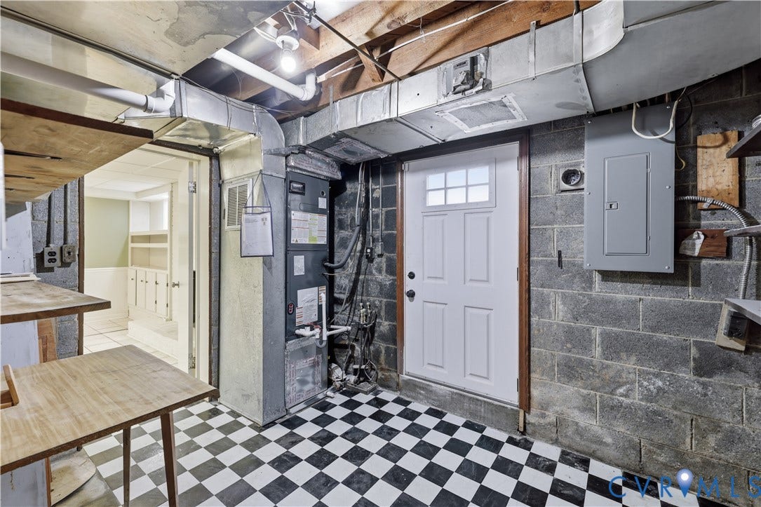 Black and white checkerboard flooring with exposed ductwork and utility systems