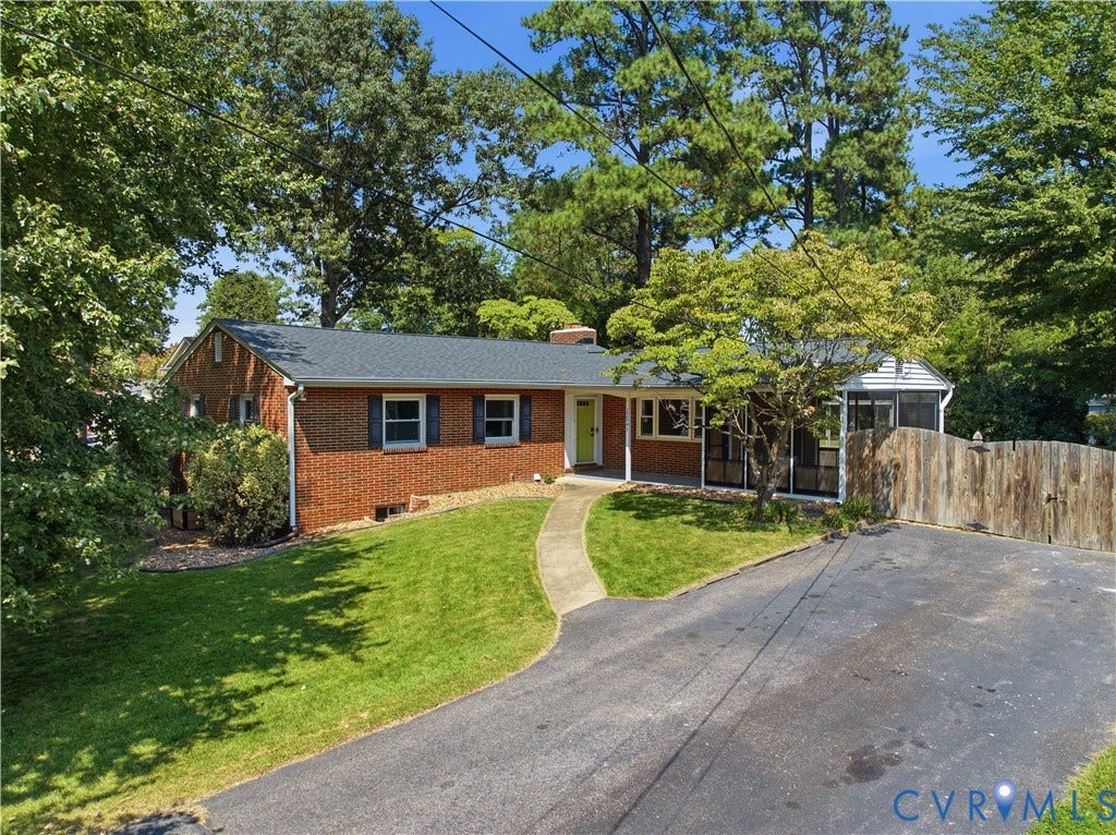 Brick exterior with a dark shingle roof and contrasting shutters