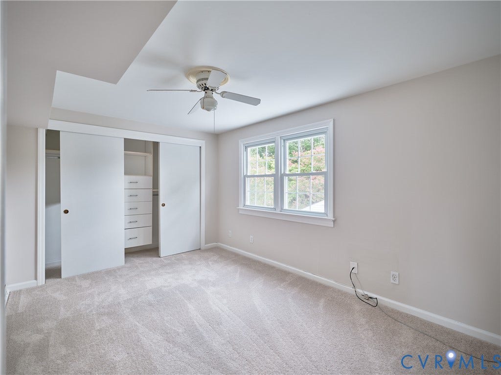 1311 Santa Rosa Road, Henrico, VA 23229 Plush carpet flooring, white trim details, window providing natural light, ceiling fan fixture, and custom closet built-ins