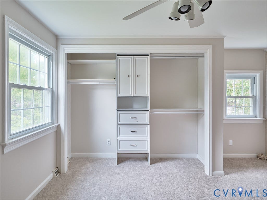 1311 Santa Rosa Road, Henrico, VA 23229 Spacious walk-in closet featuring built-in white cabinetry with dual doors, multiple shelving units, and three drawers for organized storage
