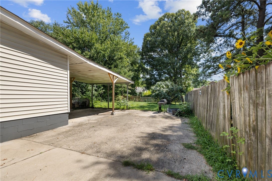 2314 Ingram Avenue, Richmond, VA 23224 Carport with concrete slab, wood fencing, and mature trees