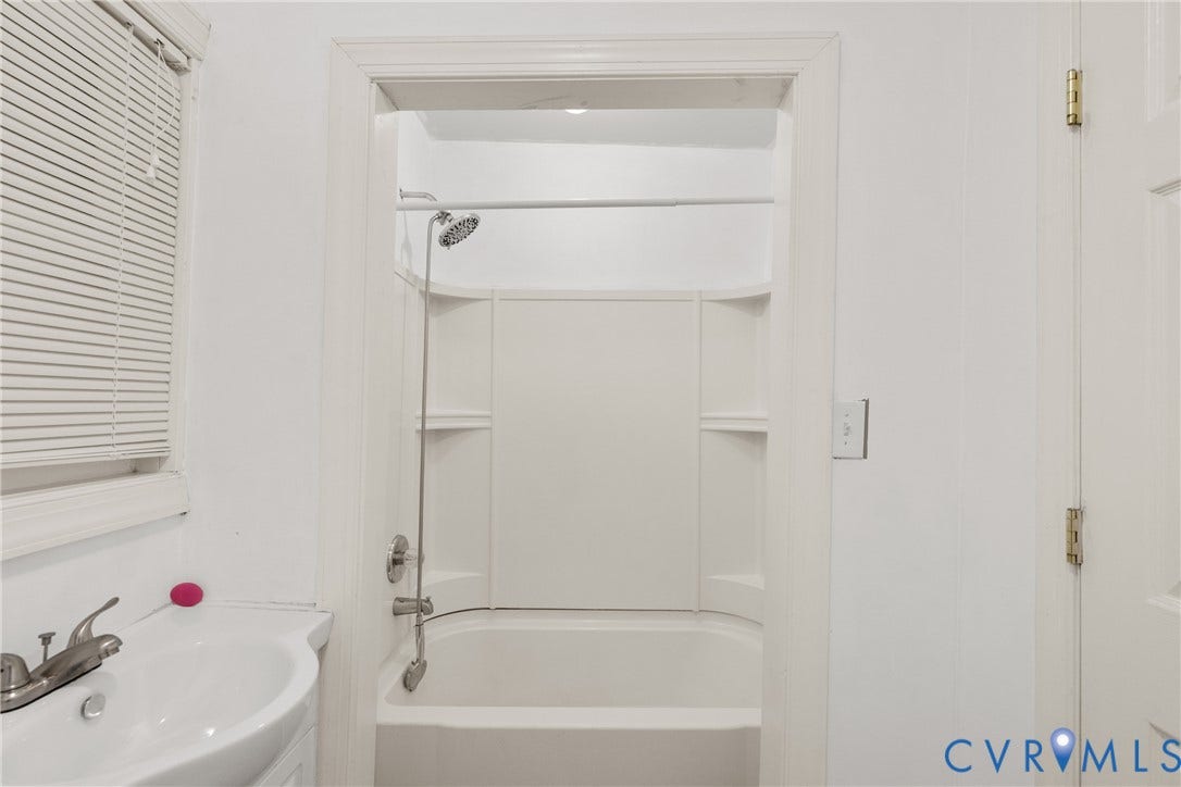 2314 Ingram Avenue, Richmond, VA 23224 White paneled bathtub and shower combination with a rain showerhead