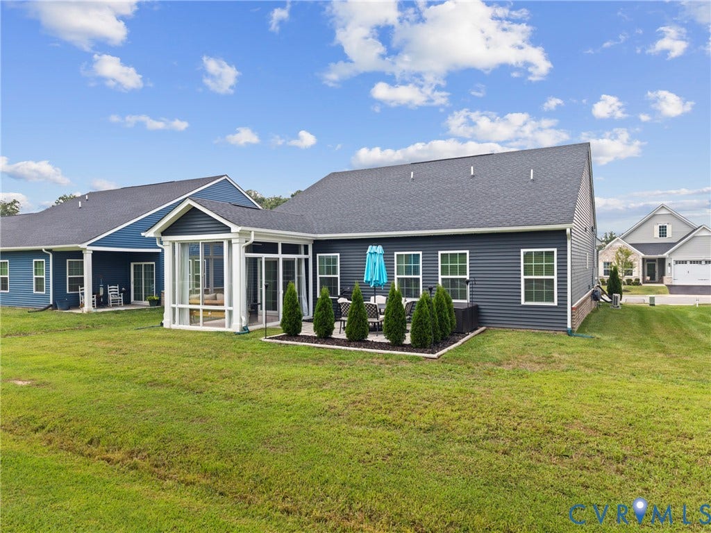 11319 Vulcan Lane, Bermuda, Chester, VA 23831 Screened porch with clear panels, rear patio area, dark siding, multiple windows, and a landscaped bed