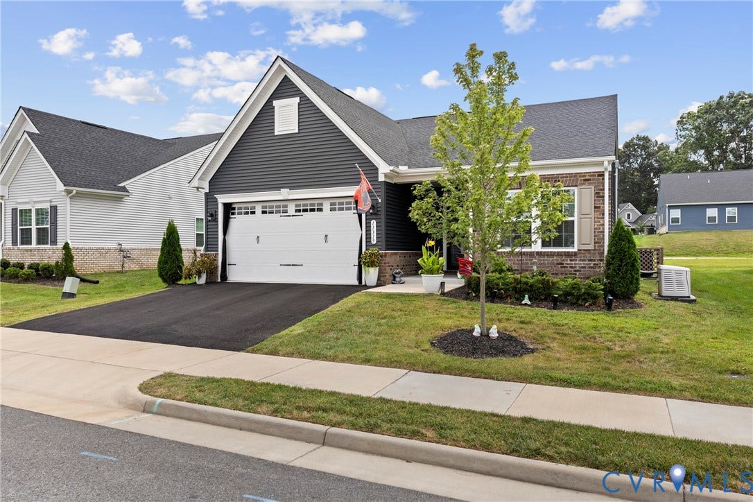 11319 Vulcan Lane, Bermuda, Chester, VA 23831 Exterior featuring dark siding, brick accents, a gabled roofline, and an attached two-car garage