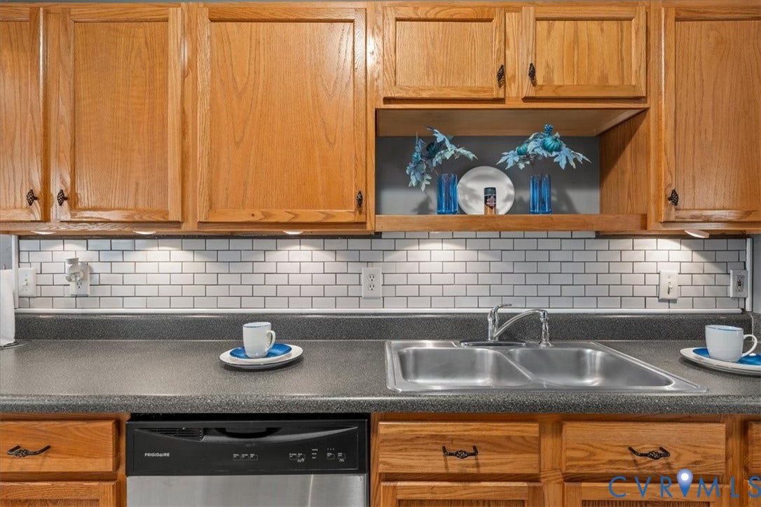 2723 Goyne Terrace, Chester, VA 23831 Wood cabinetry with accent shelf, subway tile backsplash, under-cabinet lighting, dual basin sink, and integrated dishwasher
