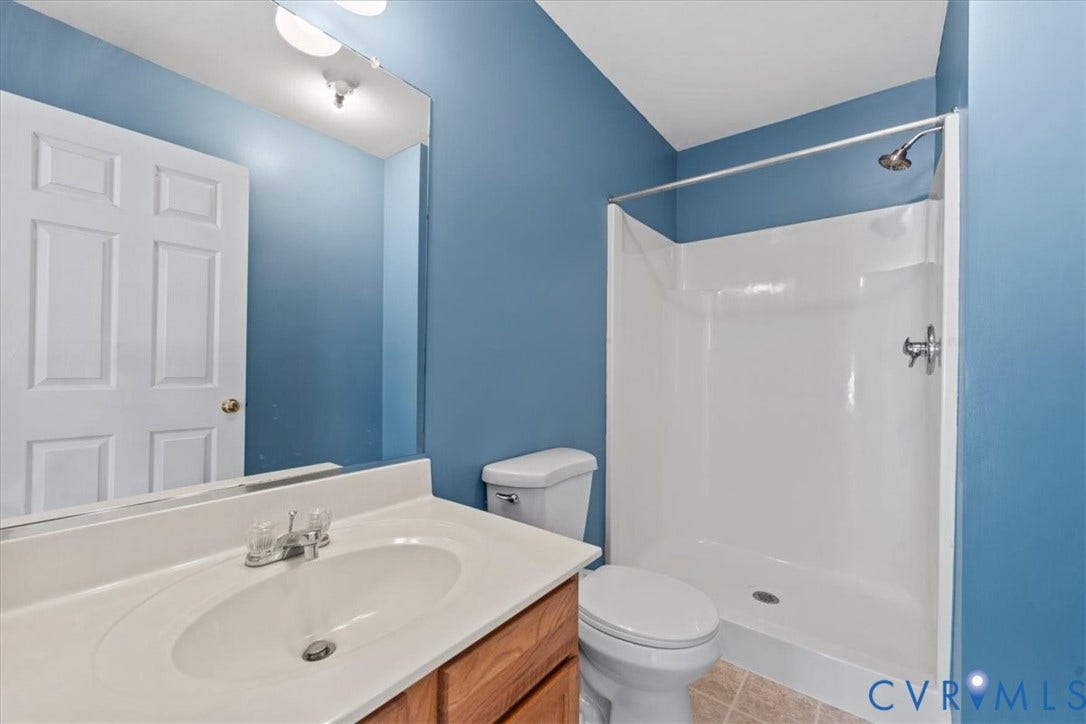 2723 Goyne Terrace, Chester, VA 23831 Bathroom featuring a single vanity with an integrated sink, wood-finish cabinetry, a full-width mirror, a stand-up shower, and ceramic tile flooring