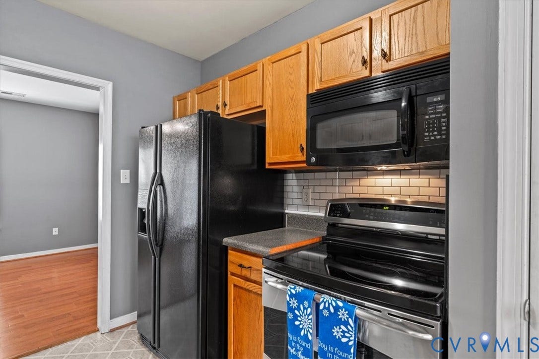 2723 Goyne Terrace, Chester, VA 23831 Kitchen featuring wood cabinetry, black appliances, subway tile backsplash, and light-toned flooring