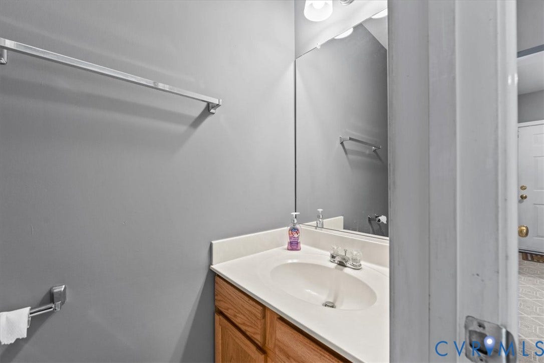2723 Goyne Terrace, Chester, VA 23831 Integrated vanity with an oval sink, chrome faucet, and wood-finish cabinetry