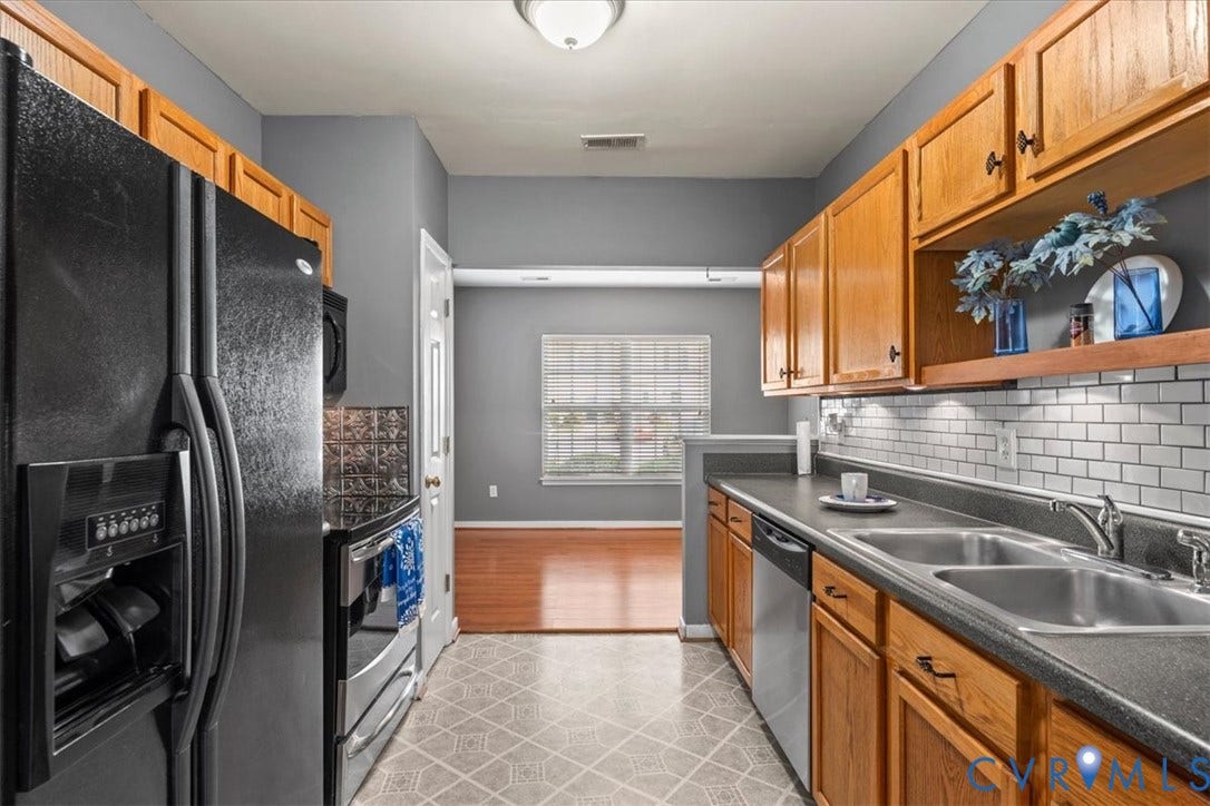 2723 Goyne Terrace, Chester, VA 23831 Galley kitchen featuring wood cabinetry, stainless steel appliances, a subway tile backsplash, and durable countertops