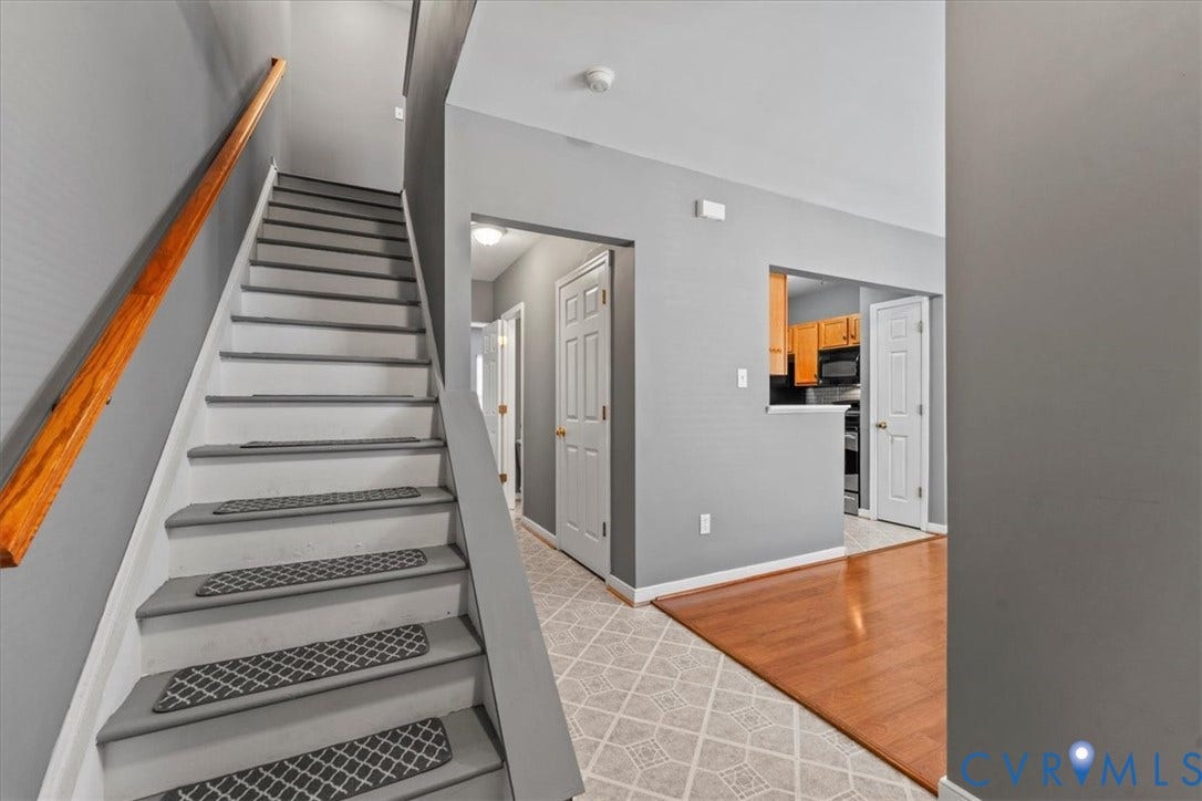 2723 Goyne Terrace, Chester, VA 23831 Staircase with wood handrail, light gray walls, wood-finish flooring, and patterned tile flooring