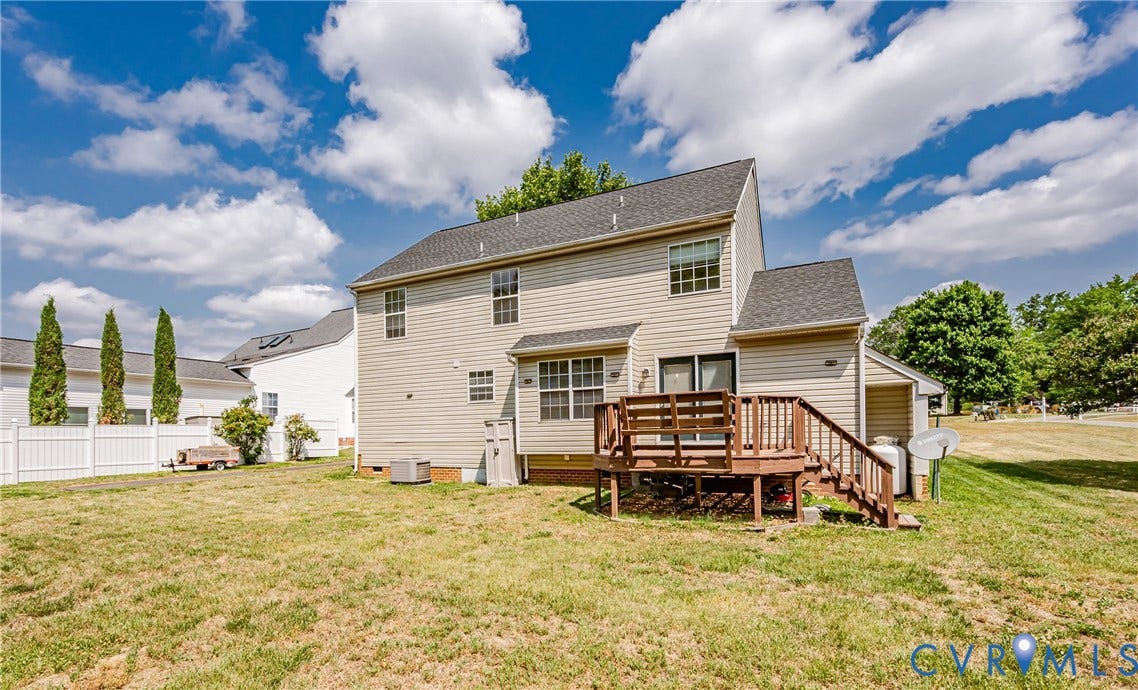 Spacious backyard with a wooden deck and privacy fencing