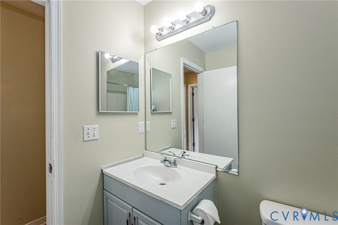 Vanity with integrated sink, chrome faucet, and under-sink storage