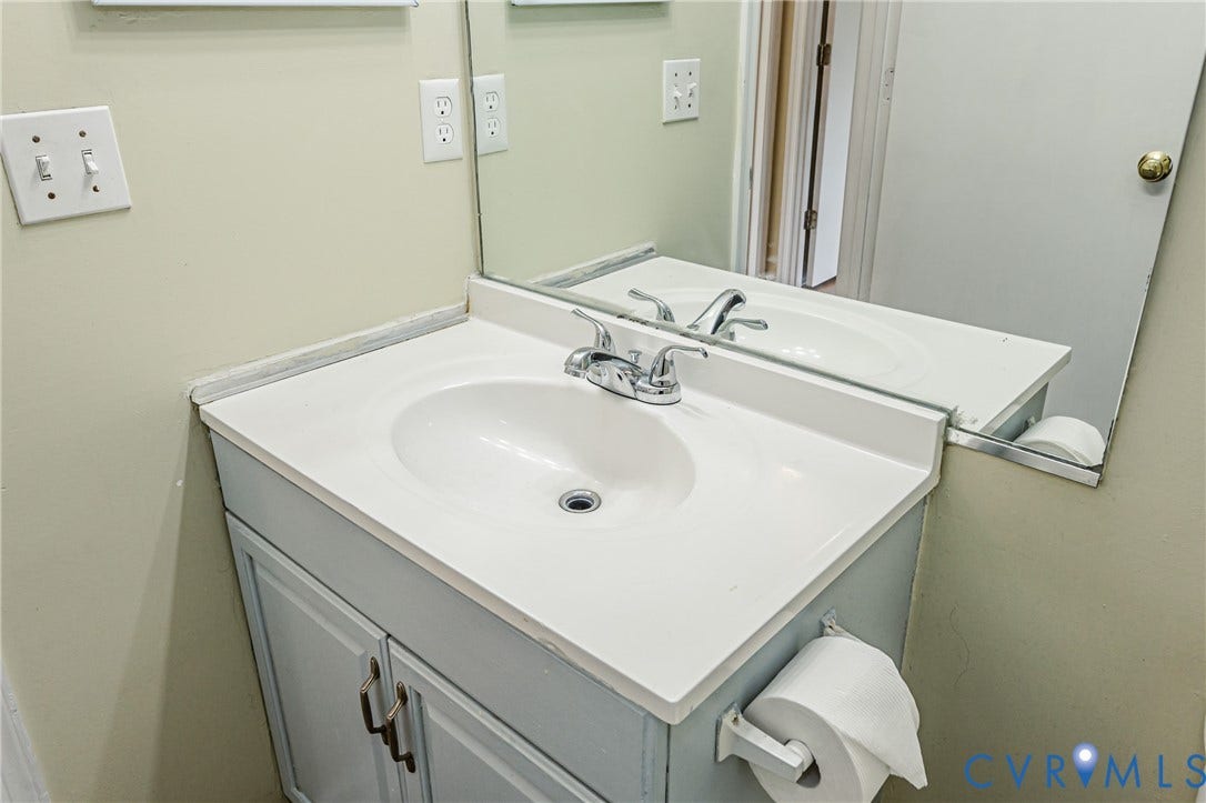 Vanity with an integrated sink, white countertop, and chrome faucet
