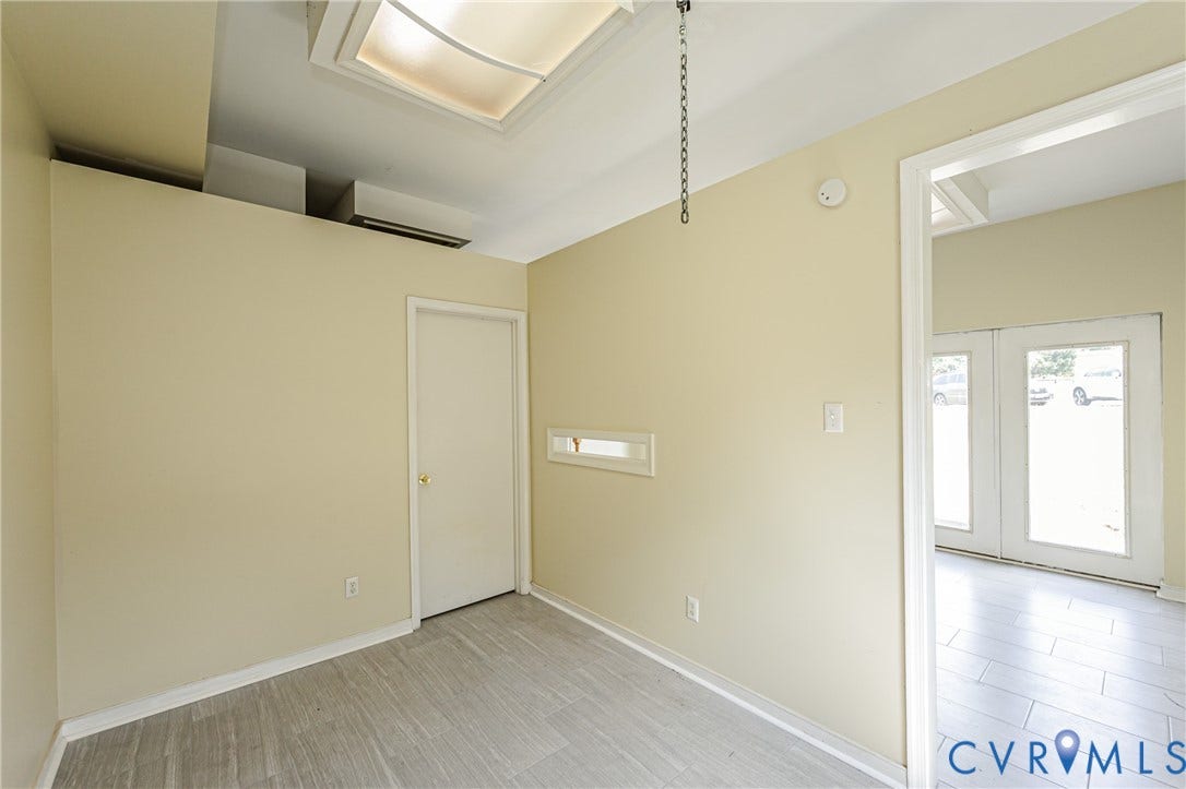 Recessed ceiling light, neutral wall palette, white interior door, light wood-finish flooring, and white trim