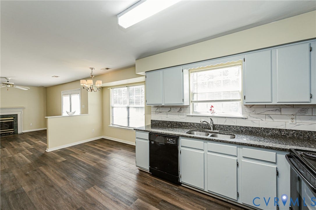 Kitchen featuring light-colored cabinetry, dark countertops, and a tile backsplash