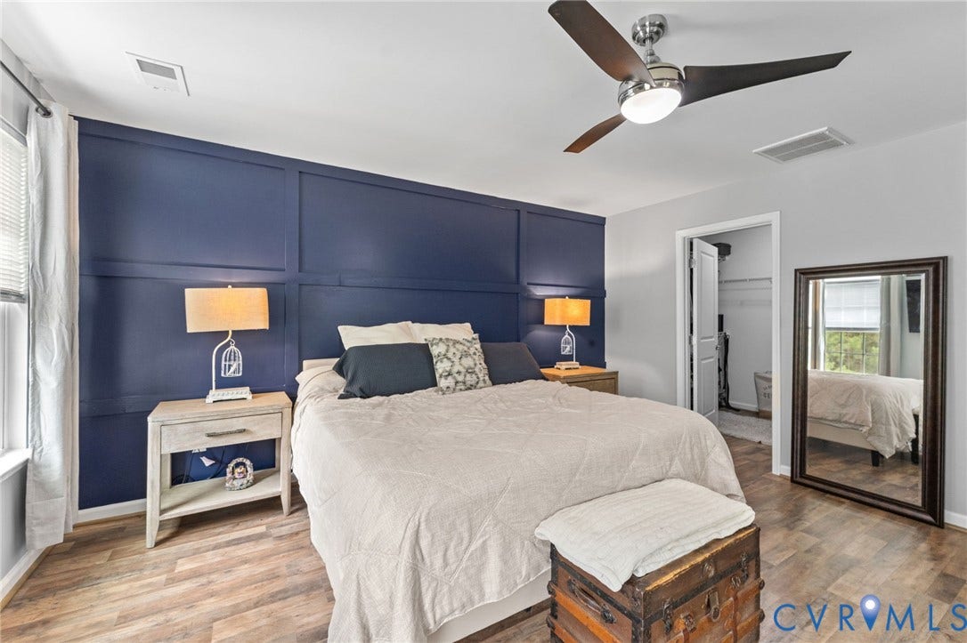 5112 Weatherby Drive, Chester, VA 23831 Accent wall with wainscoting detail, wood-finish flooring, ceiling fan with integrated lighting, and a walk-in closet with built-in shelving