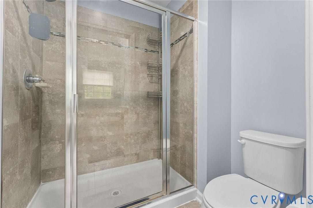 5112 Weatherby Drive, Chester, VA 23831 Shower enclosure with a clear glass panel, tiled walls, and a built-in shower niche