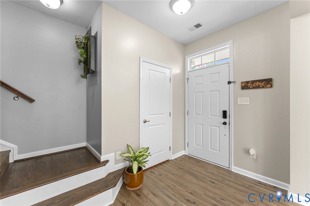 5112 Weatherby Drive, Chester, VA 23831 Wood-finish flooring, white paneled entry door with transom window, staircase with wood handrail, and flush-mount lighting