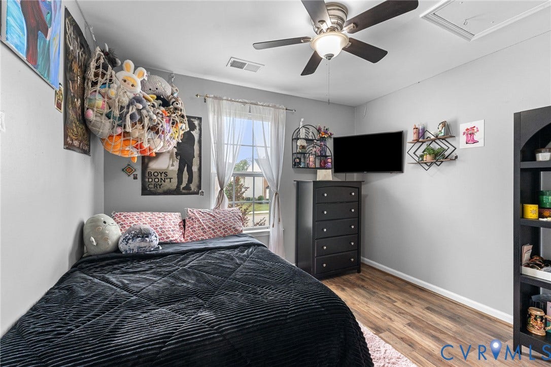 5112 Weatherby Drive, Chester, VA 23831 Wood-finish flooring, ceiling fan with integrated lighting, window with light-filtering curtains, and light gray wall paint