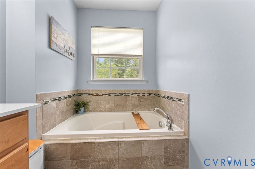 5112 Weatherby Drive, Chester, VA 23831 Built-in soaking tub with a tiled surround, accent tile band, and chrome fixtures