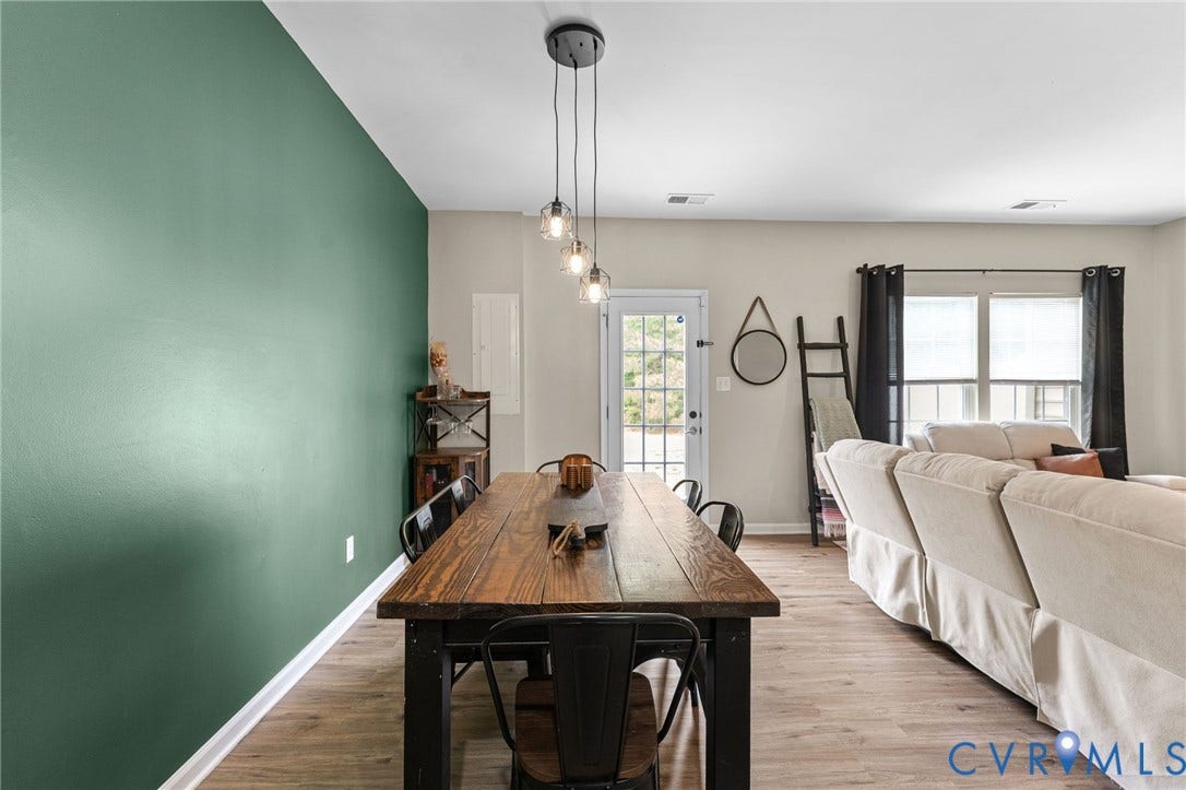 5112 Weatherby Drive, Chester, VA 23831 Open-concept living space with wood-finish flooring, a contemporary linear pendant light fixture, and a glass-paneled door