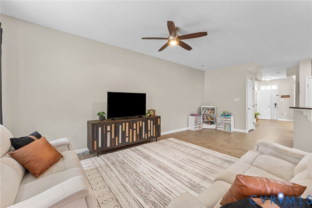 5112 Weatherby Drive, Chester, VA 23831 Spacious living area featuring high ceilings, wood-finish flooring, and a ceiling fan with integrated lighting