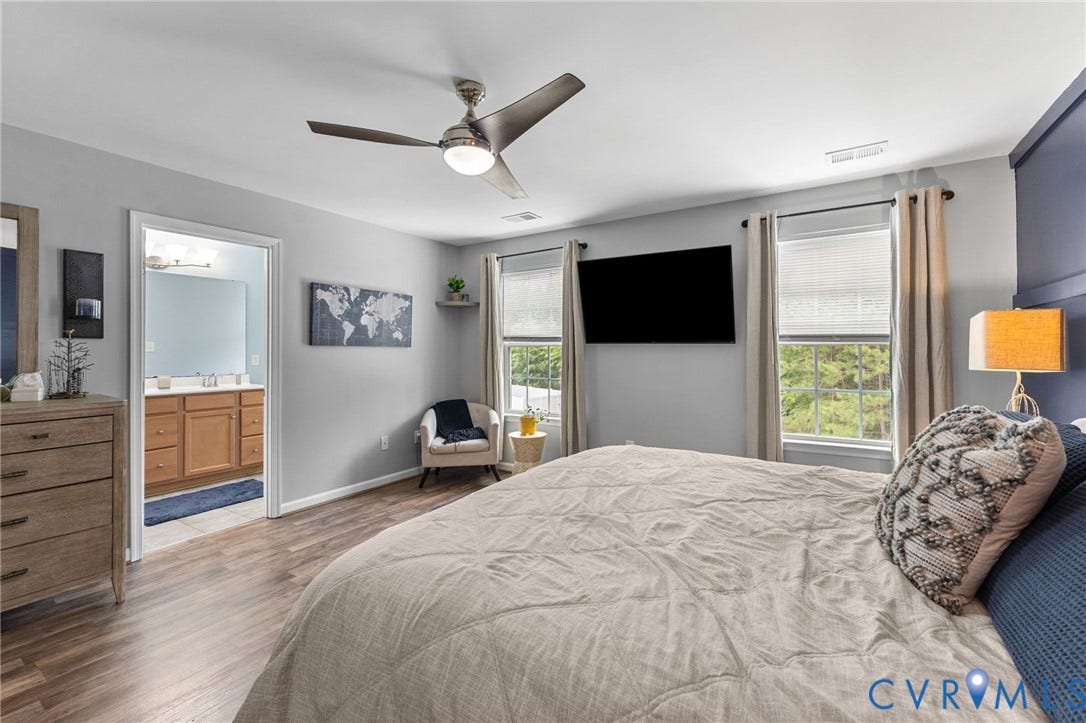 5112 Weatherby Drive, Chester, VA 23831 Wood-finish flooring, ceiling fan with integrated lighting, dual windows, and an en-suite bathroom featuring a double vanity