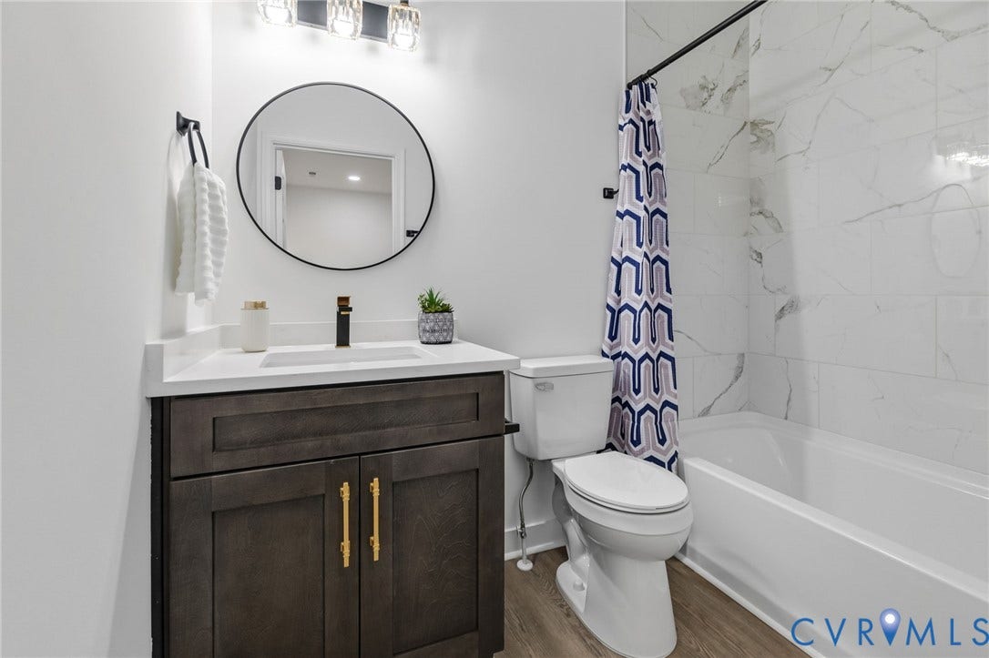 524 Cameron Street, Petersburg, VA 23803 Bathroom featuring a wood-finish vanity with gold-tone hardware, white countertop, and an undermount sink with a matte black faucet