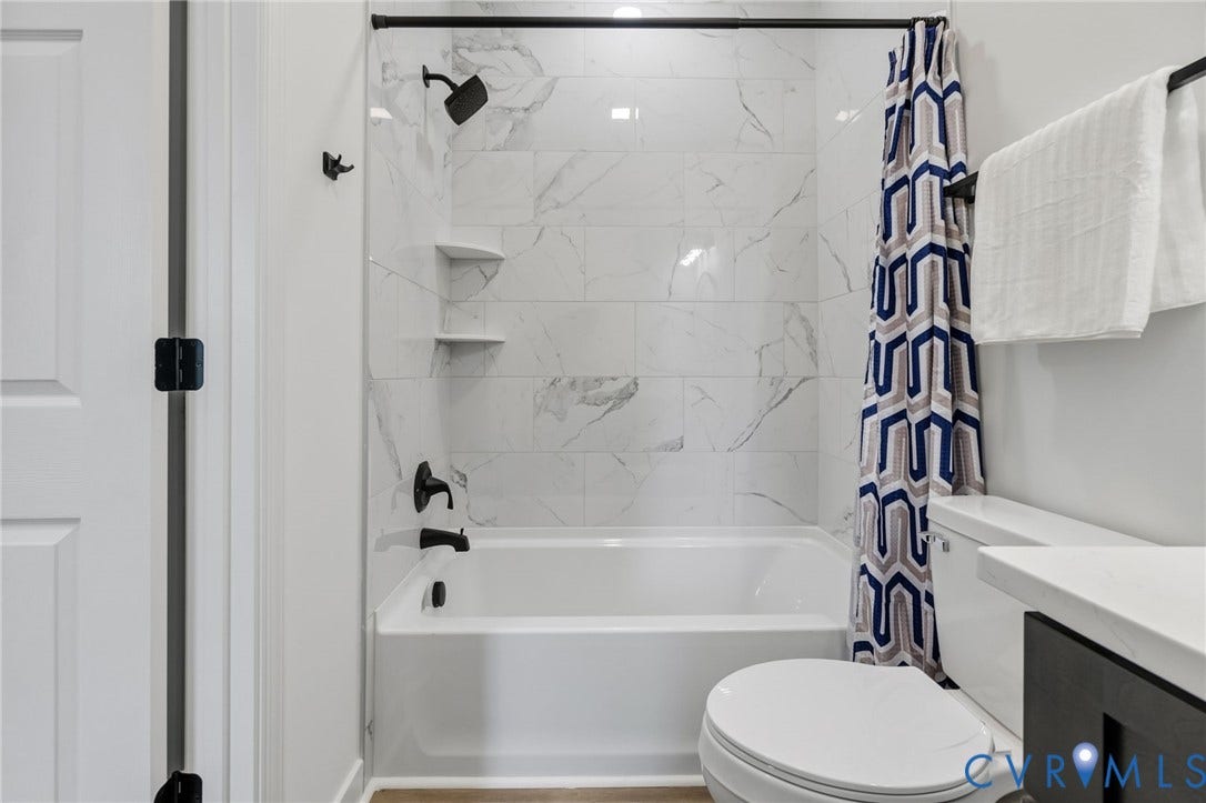 524 Cameron Street, Petersburg, VA 23803 Bathtub with white subway tile surround, matte black fixtures, and built-in shelving