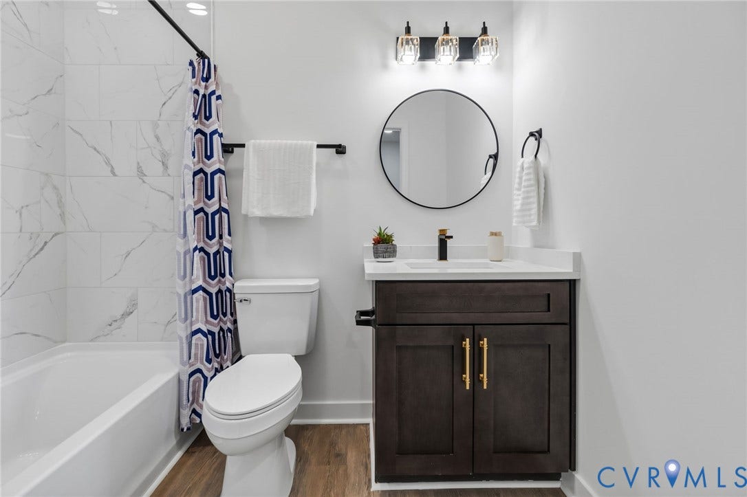 524 Cameron Street, Petersburg, VA 23803 Bathroom featuring a dark wood-finish vanity with gold-tone hardware, a circular mirror, and a three-light vanity fixture