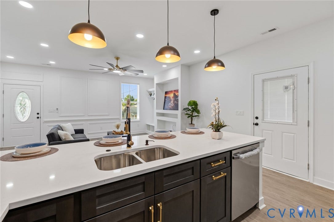 524 Cameron Street, Petersburg, VA 23803 Kitchen island with an undermount double-basin sink, dark wood-finish cabinetry, and a light-toned countertop