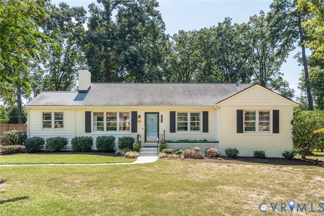 Single-story residence featuring a gray shingled roof, white brick and siding exterior, and black window shutters