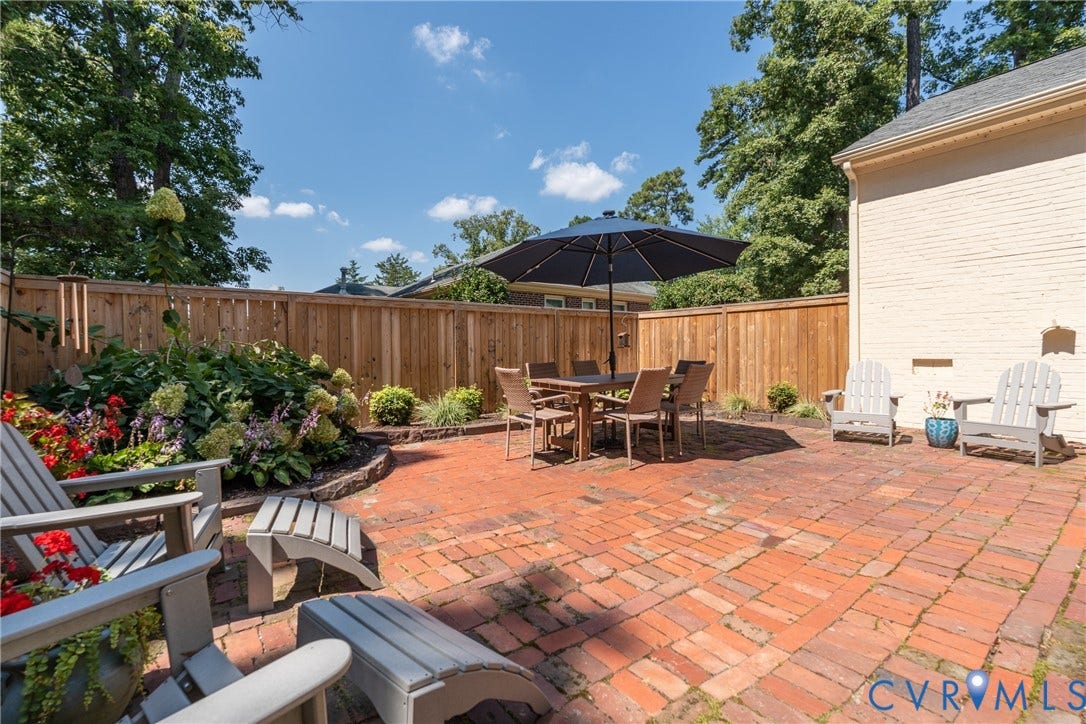Brick patio with perimeter fencing and mature landscaping