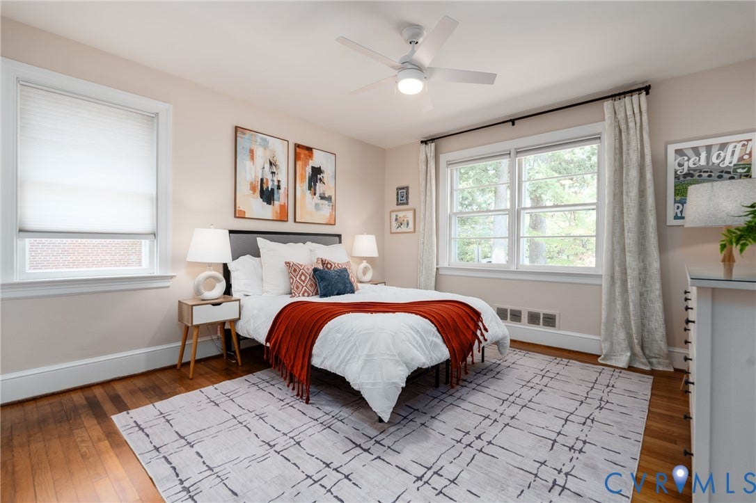 Hardwood flooring, multiple windows with white trim, and a ceiling fan with integrated lighting