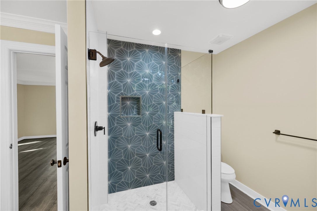 The tiled walk-in shower offers a sleek, modern touch in the primary bath.