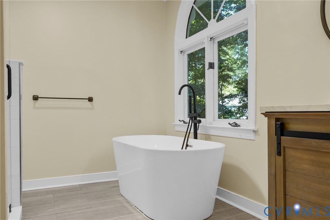 A freestanding soaking tub adds a touch of luxury to the primary bath.