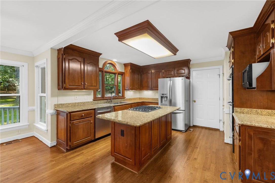 Granite countertops and abundant cherry cabinetry give the kitchen a warm, timeless feel.