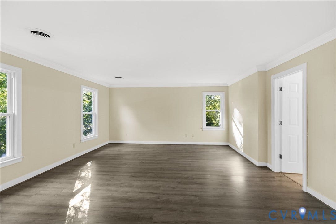 Primary bedroom w/ vinyl flooring, spa like primary bathroom and walk in closet. Small sitting room attached.