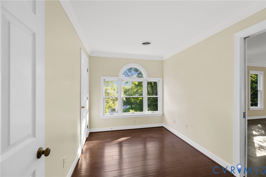 Large windows fill the sitting room with natural light, extending the primary suite's living space.