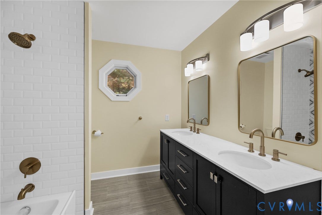 The hall bath features a double vanity, quartz counters, and tile flooring shared by the secondary bedrooms.