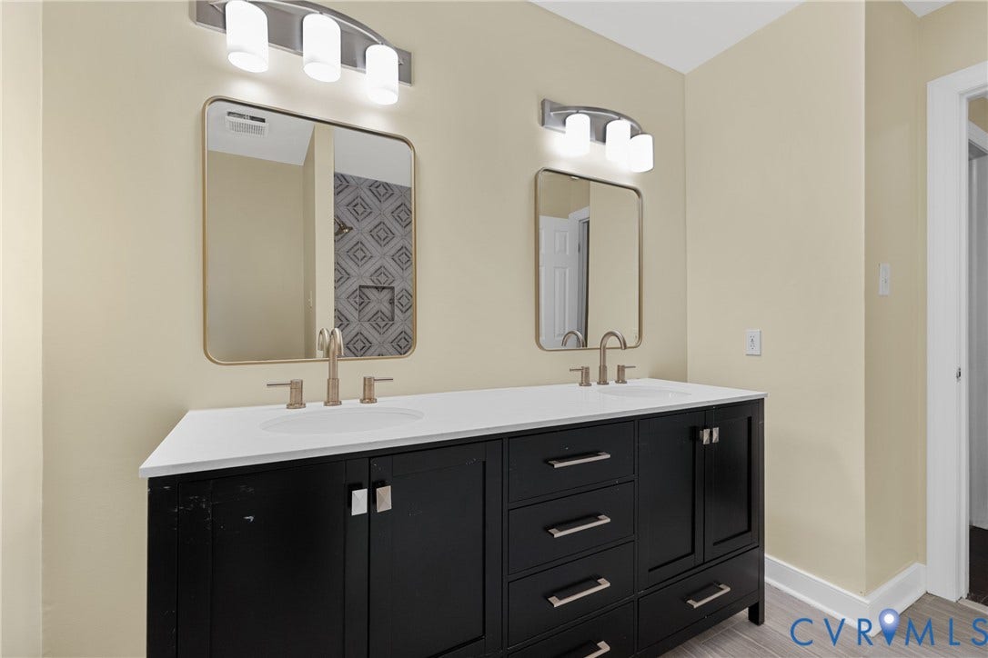 The hall bath features a double vanity, quartz counters, and tile flooring shared by the secondary bedrooms.